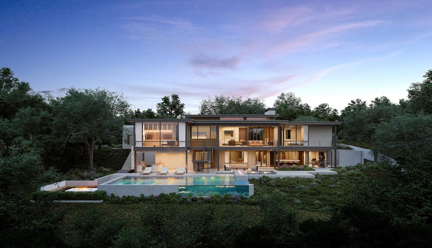 A modern, two-story house with large windows is surrounded by lush greenery. The home features an outdoor swimming pool with a patio area and sun loungers. The warm interior lighting of the house contrasts with the twilight sky above.